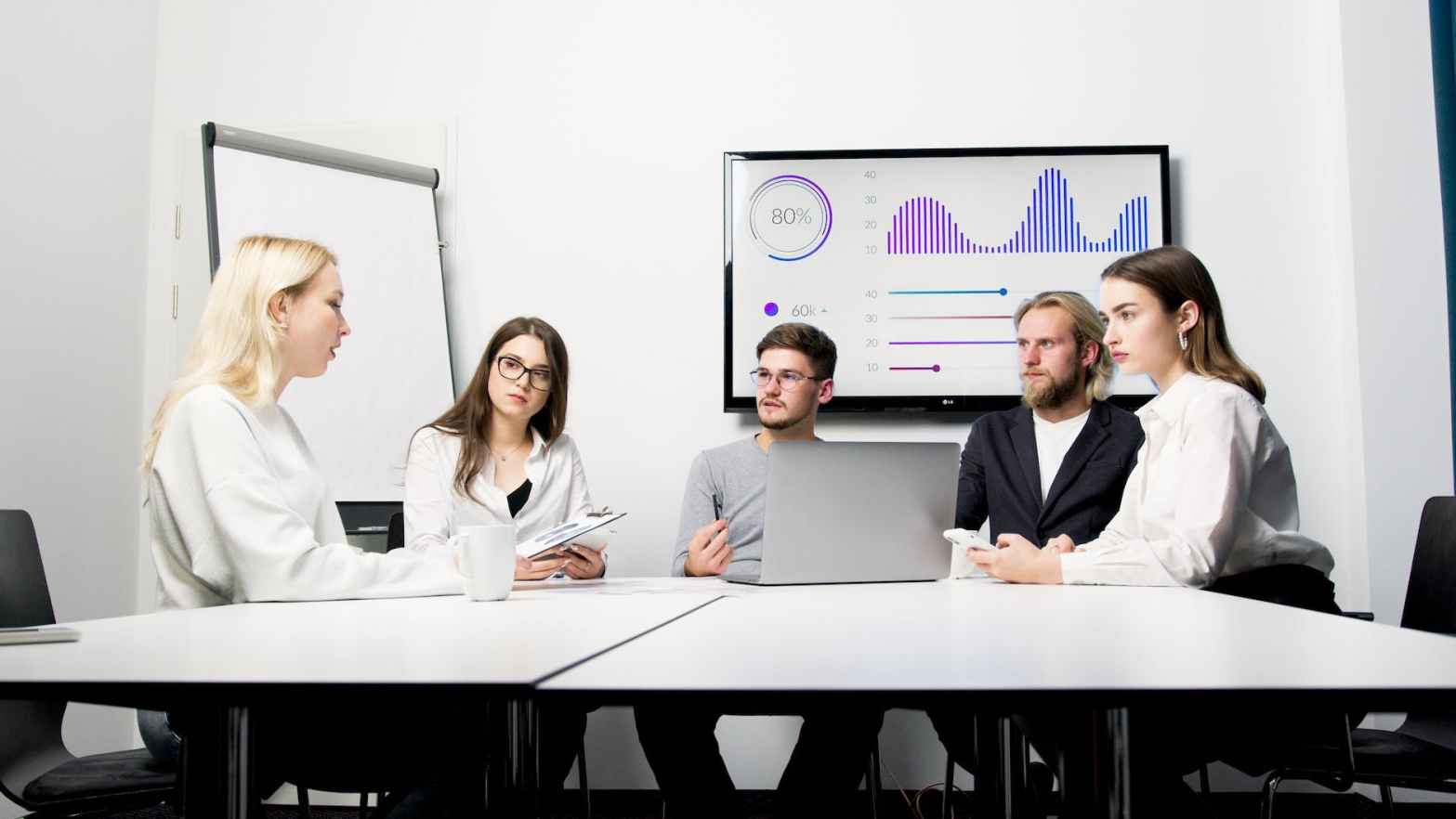 a group of people sitting in a conference room having a meeting